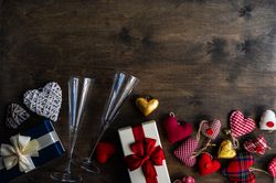 Top view of glass champagne flutes with gifts and Valentine ornaments