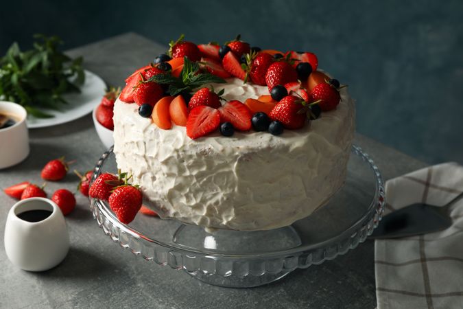 Composition with delicious berry cream cake on gray table. Tasty dessert