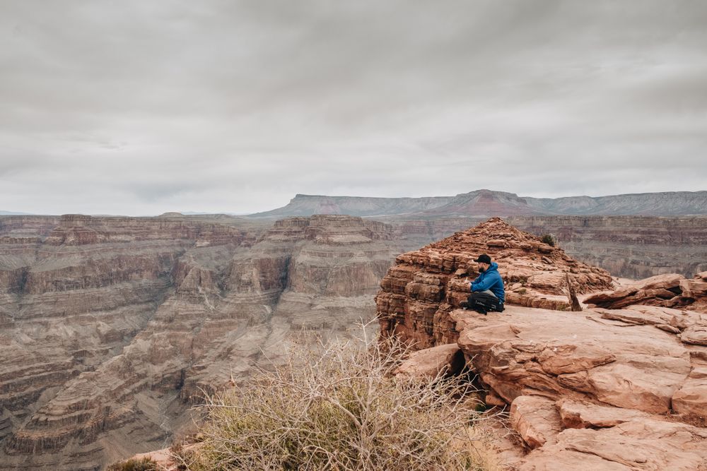 Male relaxing on cliff and admiring picturesque view