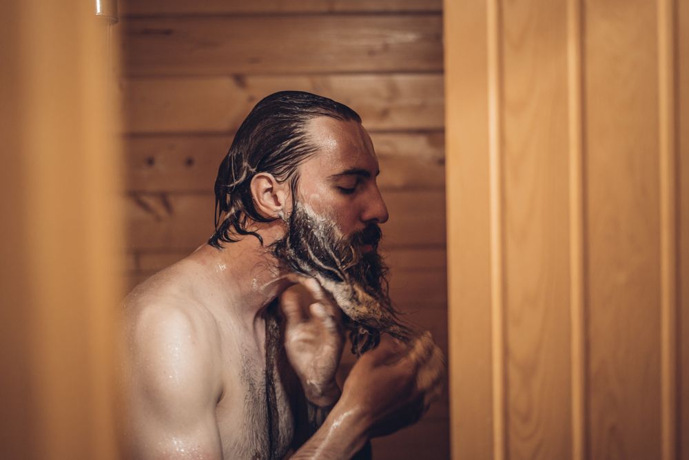 Man taking shower in wooden bathroom