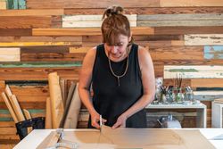Fashion designer cutting clothes patterns at her studio