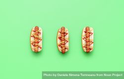 Barbecued hot dogs with ketchup and mustard over bright green background 5nDZDb