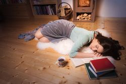 Woman sleeping surrounded by books