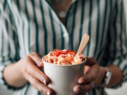 Hand holding rolled ice cream in cone cup