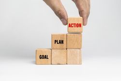 male hand put goal, plan, action words text on stack wooden