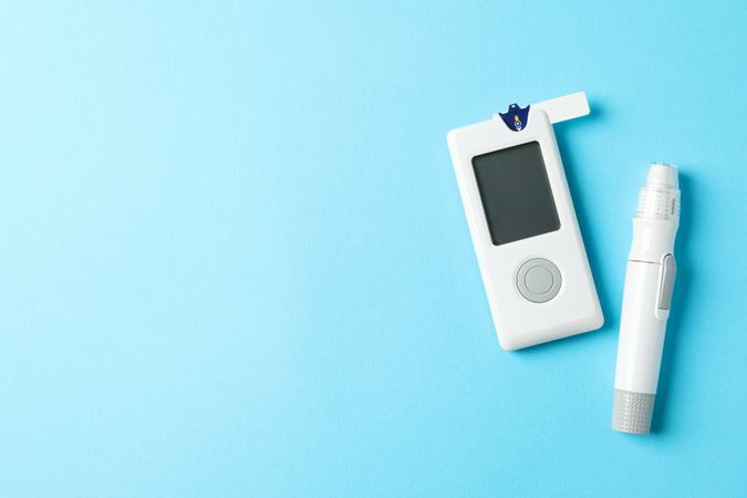 Blood glucose meter on blue background, space for text