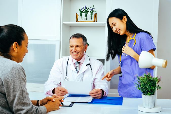 Smiling doctor discussing file with patient in office