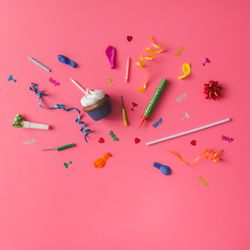 Colorful party items on pink background