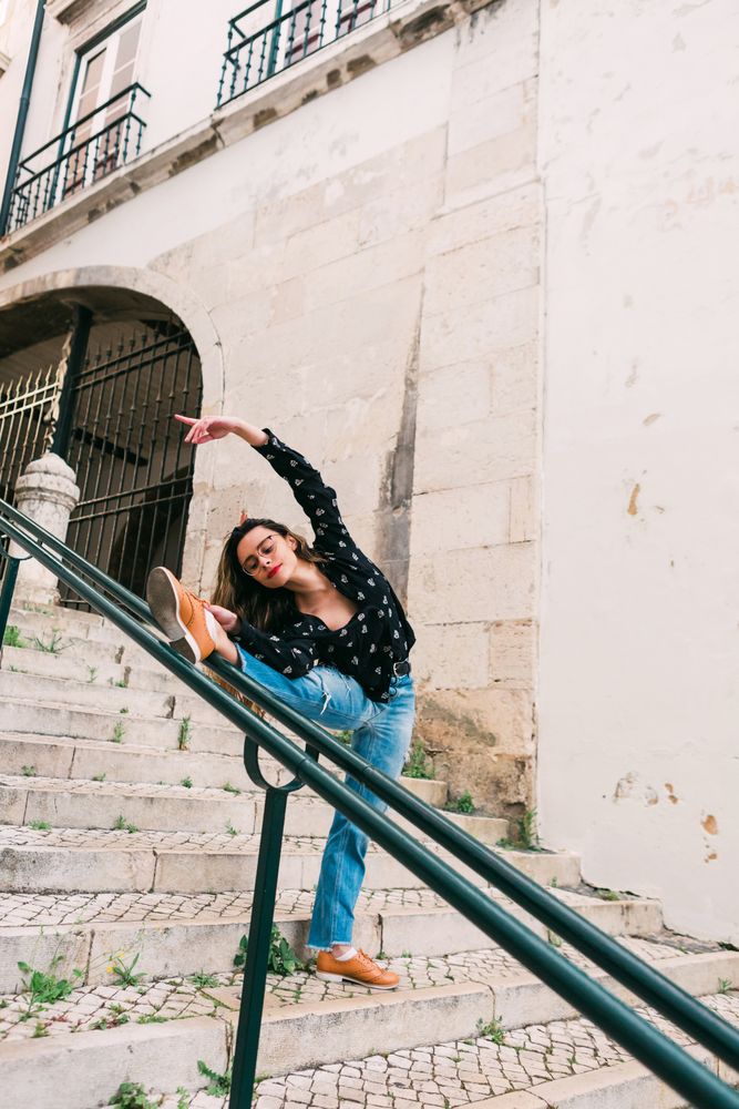 Casual woman dancing on old city street