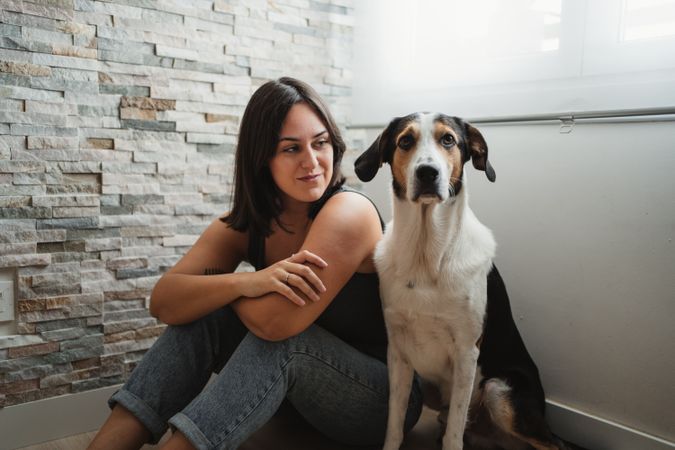 Woman with dog sitting on floor
