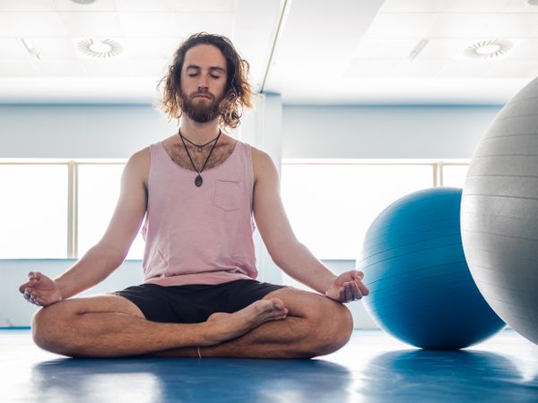 Male meditating in spacious room