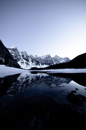 Reflection of snow covered mountain on still lake