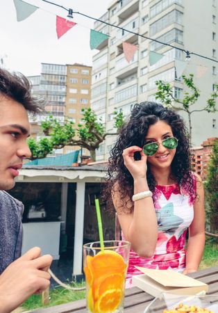 Friends sitting in backyard with drinks and books