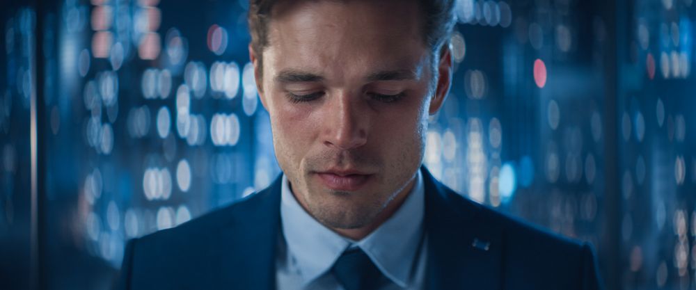 Close Up Portrait of White Businessman in Stylish Suit Posing Next to Window in Big City Office