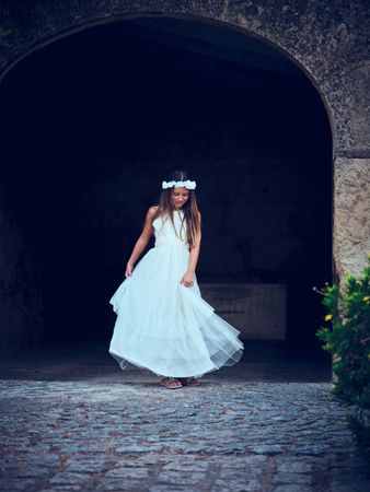Woman in white dress and hat standing on street