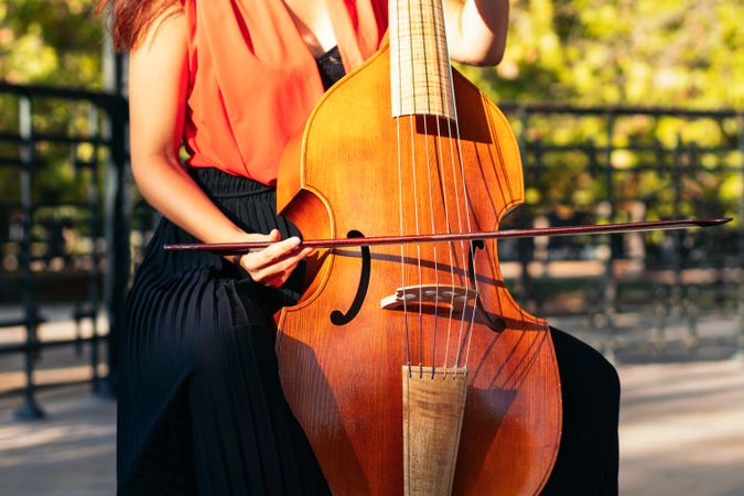 Cropped shot of an unrecognizable woman playing the cello outdoors