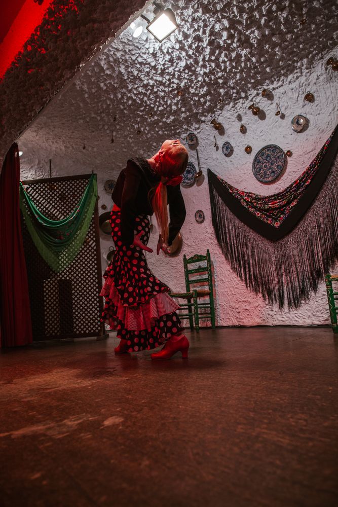 Woman dancer in flamenco costume standing in dance posture