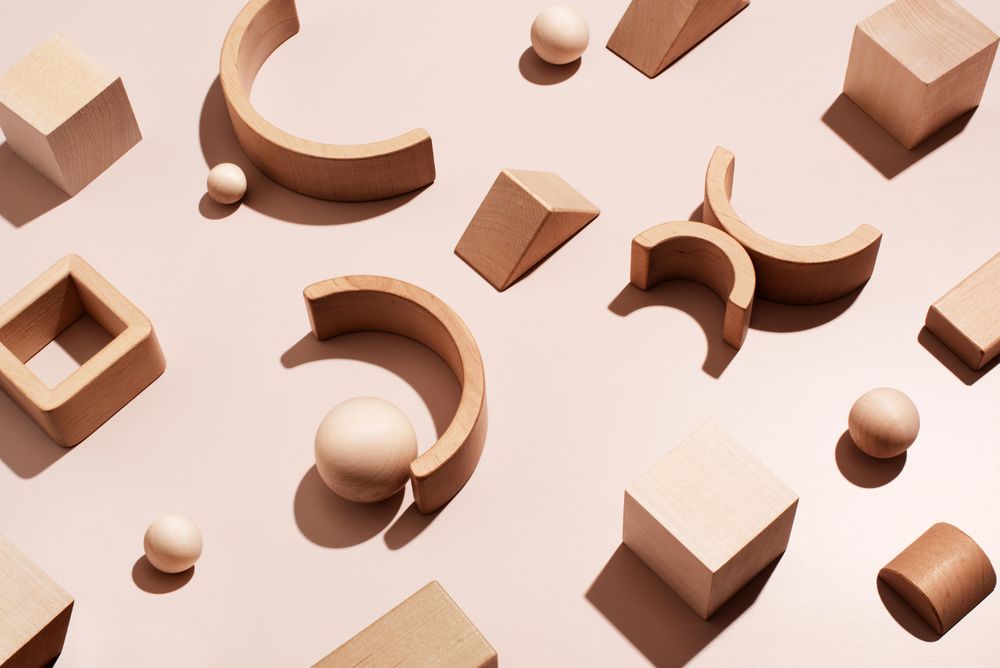 Different wooden shapes on neutral background