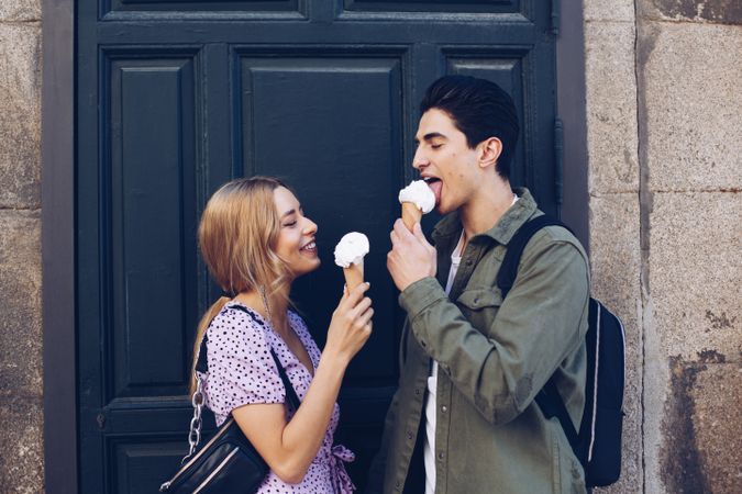 Happy couple feeding each other by ice cream
