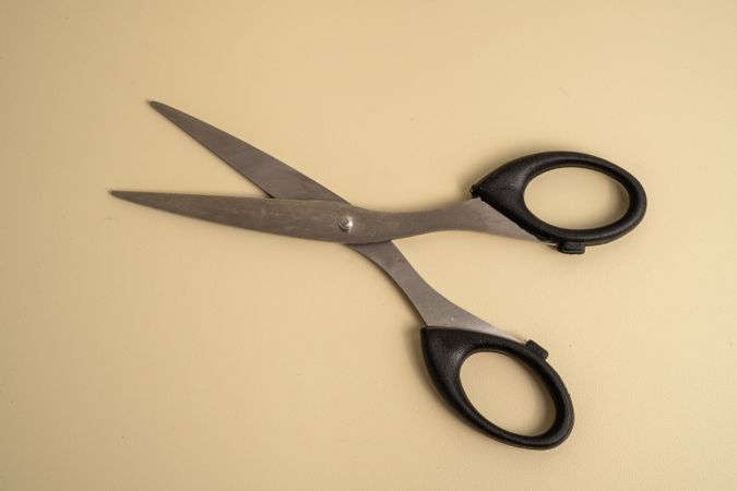 A pair of scissors is laying on a table