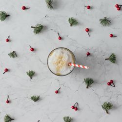 Holly and pine pattern on marble background with coffee