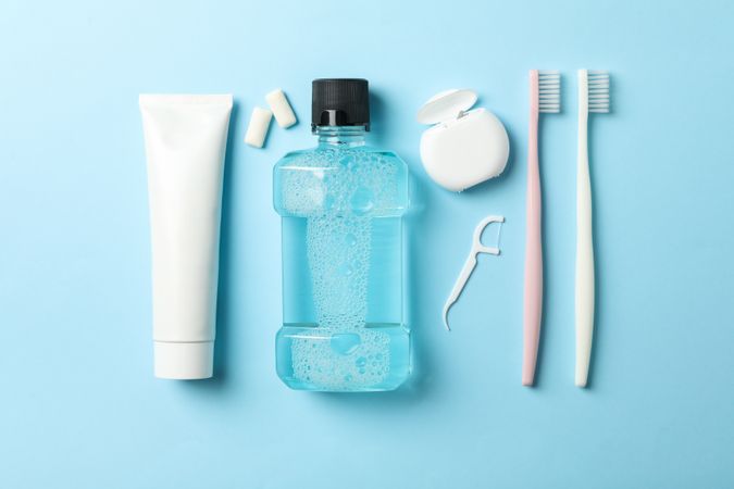 Flat lay with tools for dental care on blue background