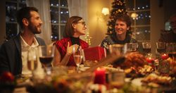 Family and Friends Gather at Home in the Evening for a Traditional Christmas Dinner with a Turkey Roast Feast