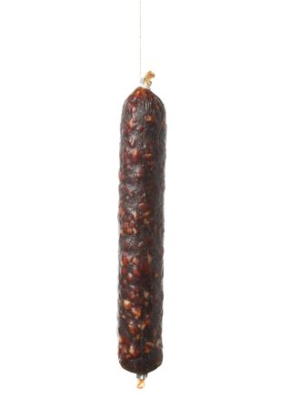Dark cured meat stick hanging in plain room