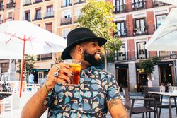 Black man having a drink in a bar terrace