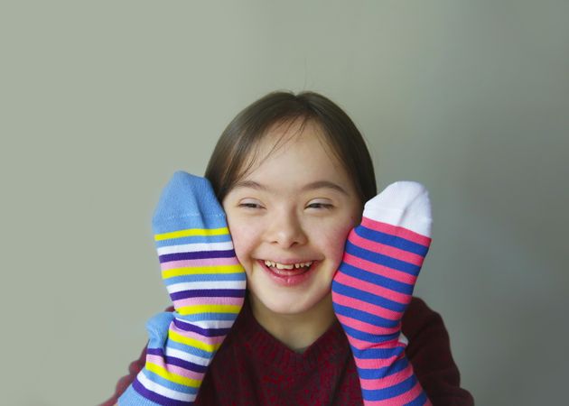 Happy girl playing hand puppets with socks covering her hands