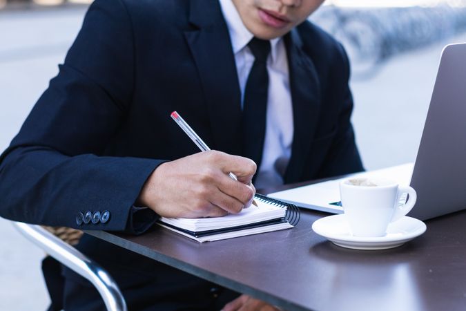 Serious male entrepreneur in suit working in cafe