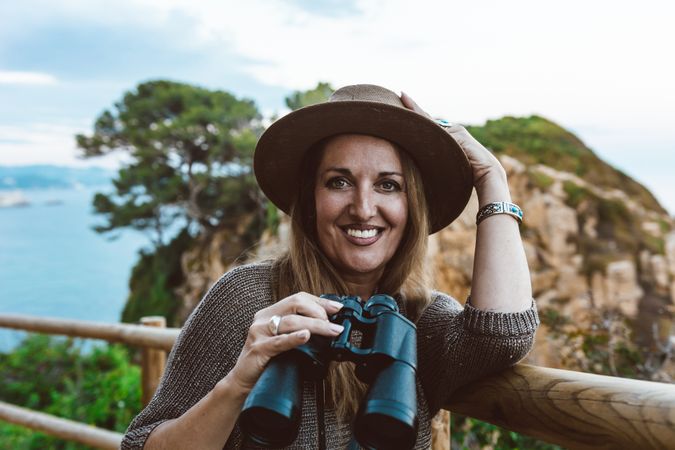 Woman with binocular on coastal walkway