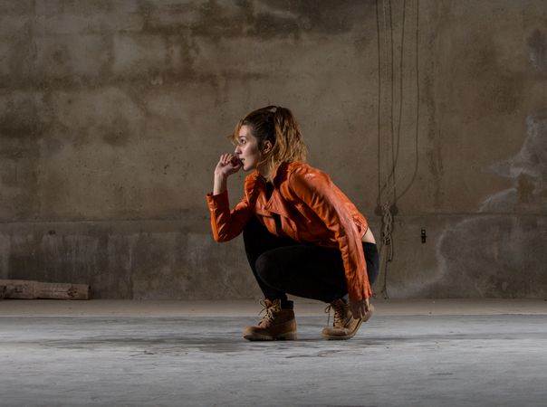 Young woman jumping in grey room