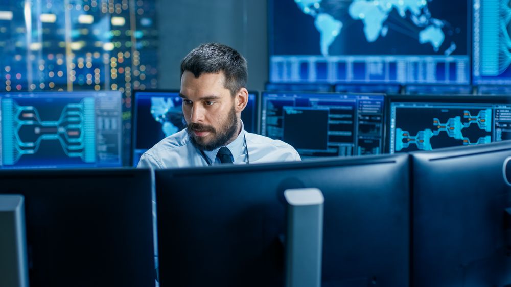 In the System Control Center Operator Working Surrounded by Displays Showing Relevant Data.