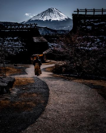 Back view of person walking on pathway near Fuji mountain in Japan