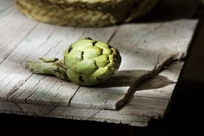 Green artichoke on wooden table