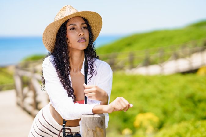 A stylish woman in a widebrim sun hat enjoying the beautiful beach environment