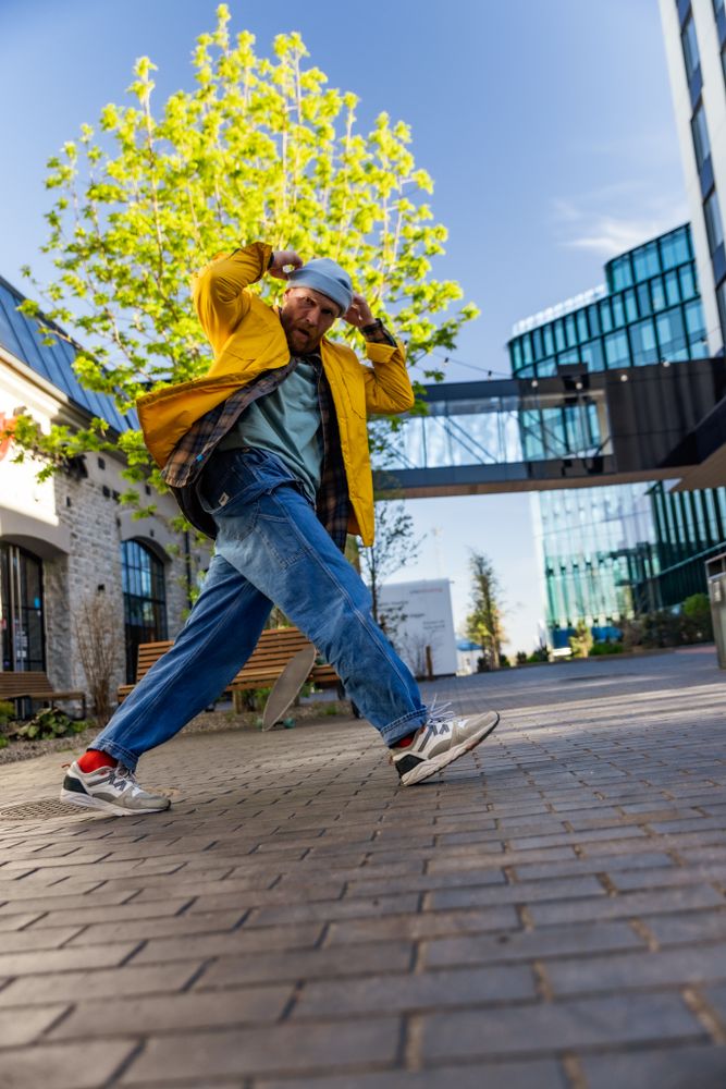 Vertical Screen: Young And Athletic B-Boy Breakdancing To Break Beats On The City Street Among Buildings Alone.