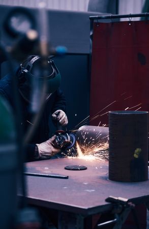 Professional welder in mask welding metal