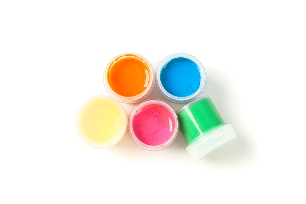Color gouache paint cans isolated on studio background, top view