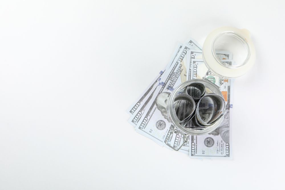 Jar with Dollar bills on light background