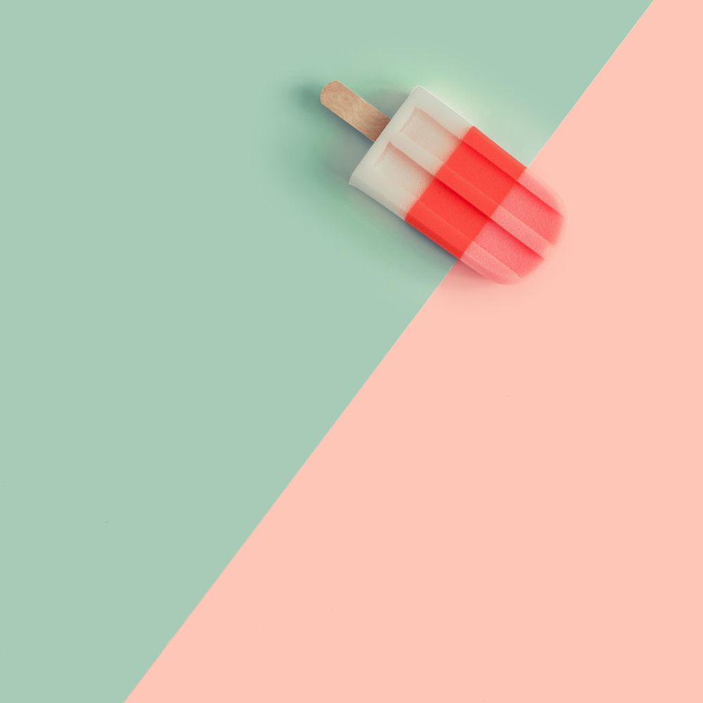 Ice cream popsicle in pastel pink on paper duotone background