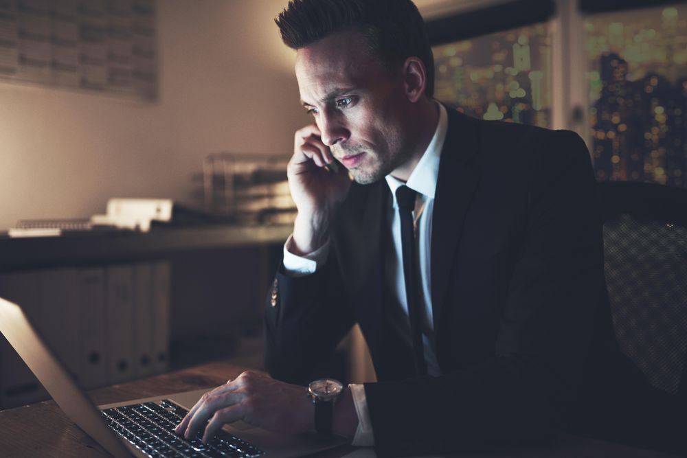 Businessman in suit talking on cellphone at night