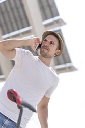 Shot looking up at man talking on phone under modern building