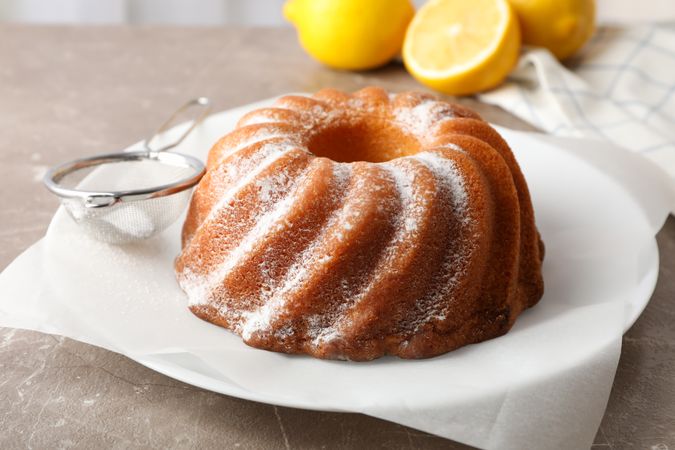 Cake with powder sugar on grey table, close up