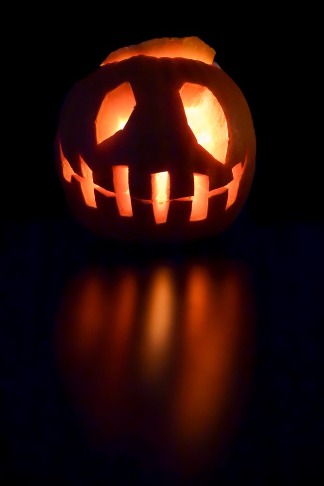 Lit pumpkin Jack-O-Lantern with reflection