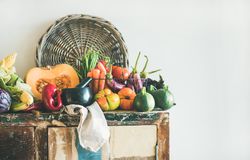 Fresh autumnal produce on kitchen counter, with halved squash, and thatched basket with copy space