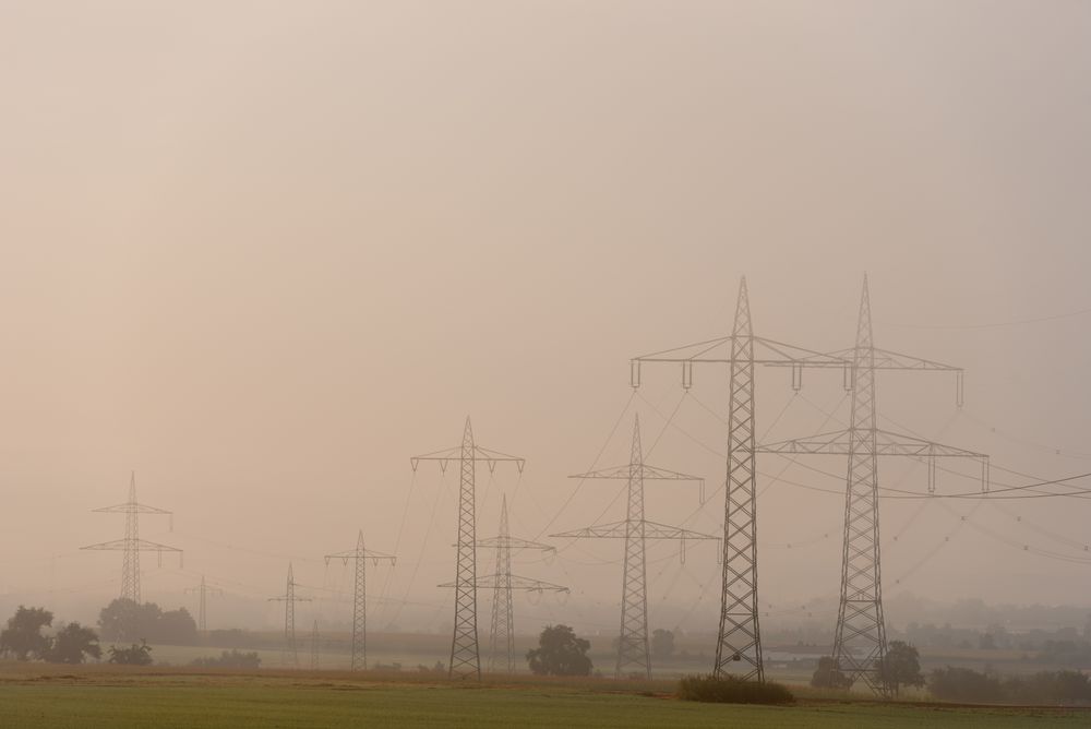Electricity pylons in a german rural scenery on a foggy morning
