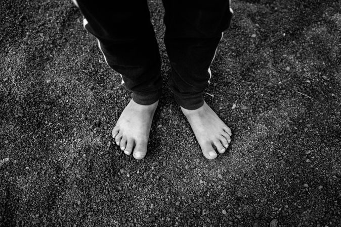 B&W shot of boys feet standing on small rocks