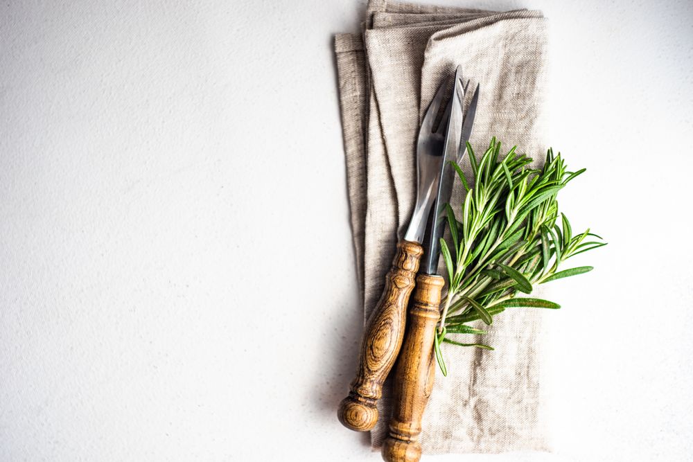 Rustic table setting with fresh rosemary sprig and copy space
